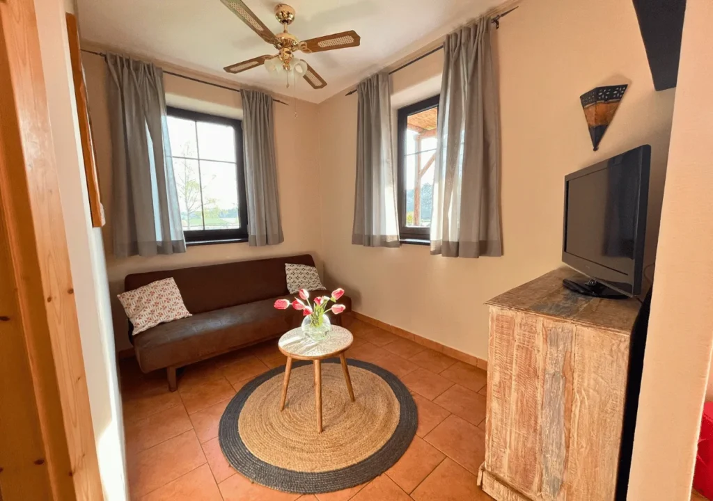 Sitzecke mit Sofa, Deckenventilator und Fernseher im Pueblo