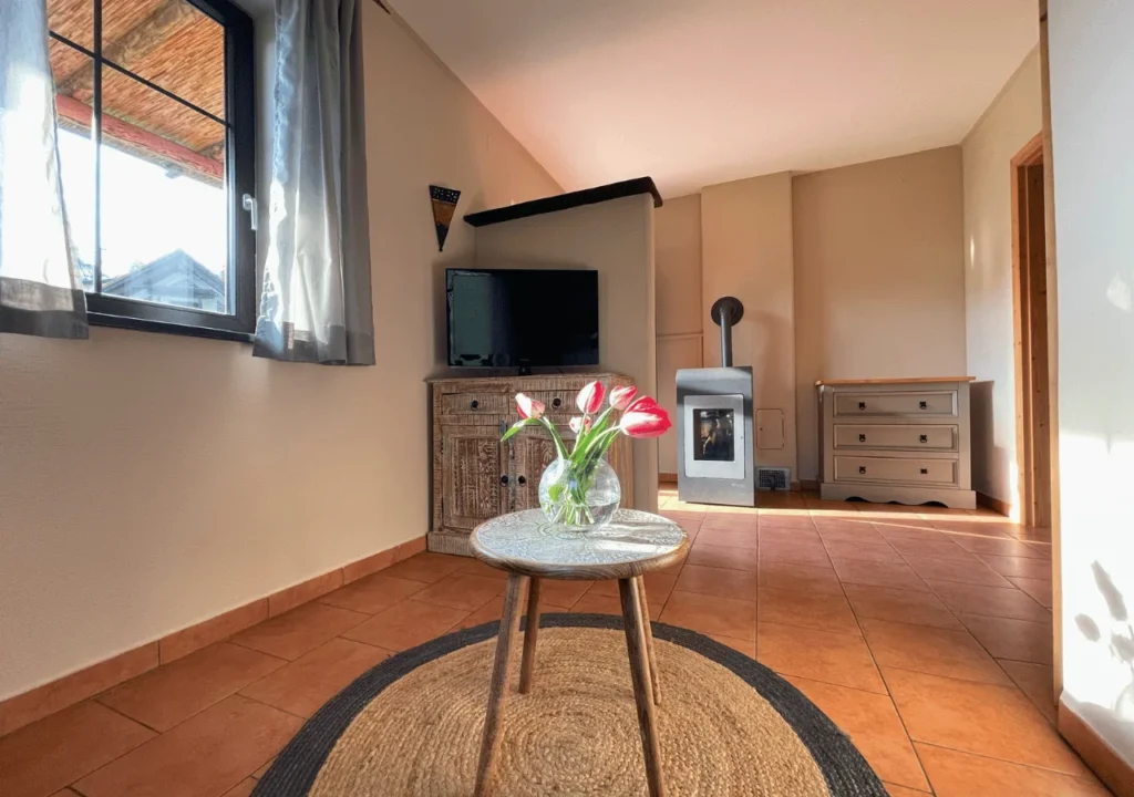 Wohnbereich im Pueblo mit Kaminofen, Fernseher und Couchtisch